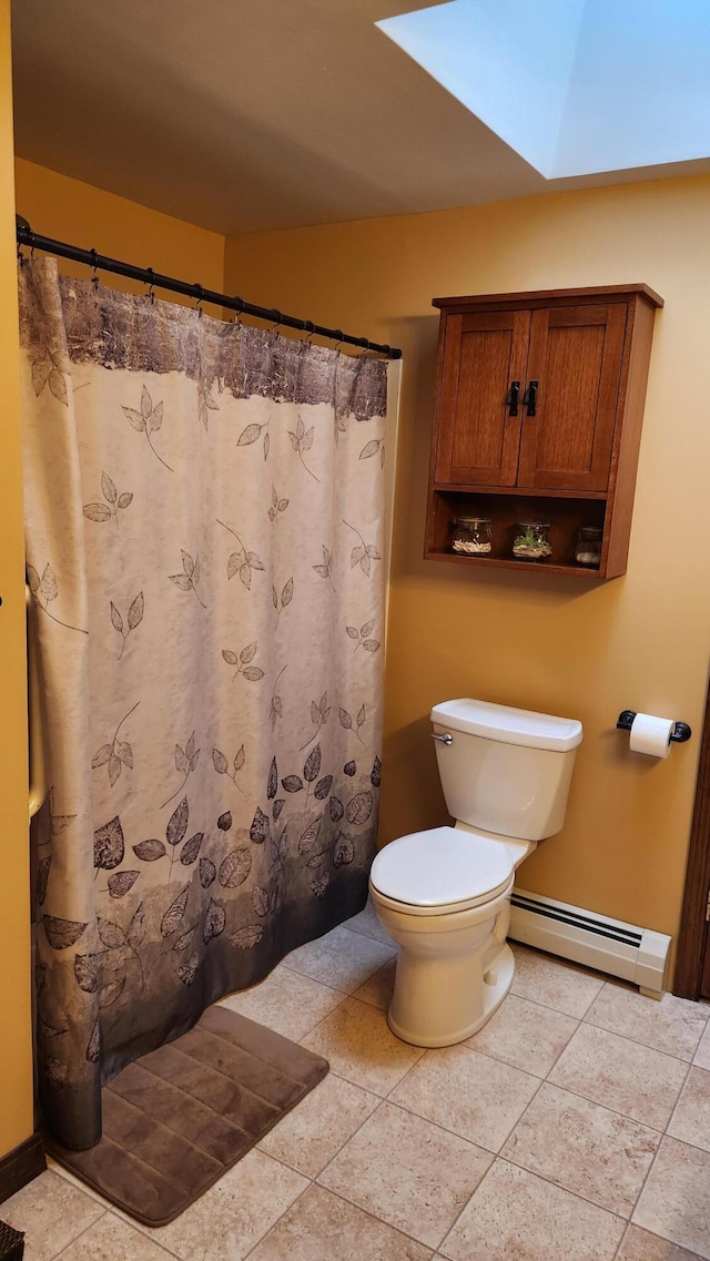 bathroom with a baseboard heating unit, tile floors, a skylight, and toilet