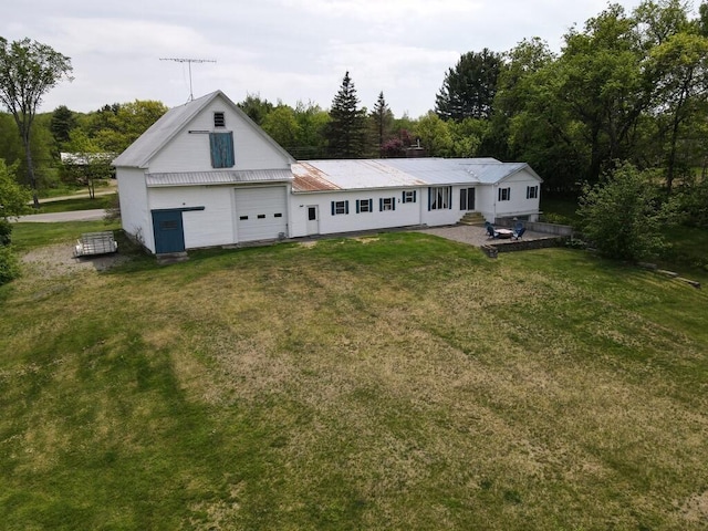 back of house featuring a garage and a lawn