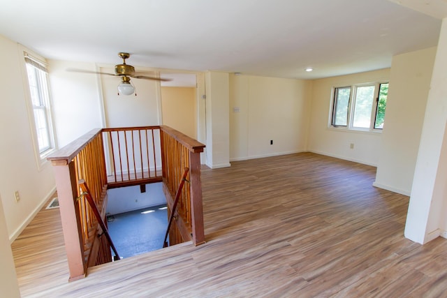 spare room with light hardwood / wood-style floors, ceiling fan, and a wealth of natural light