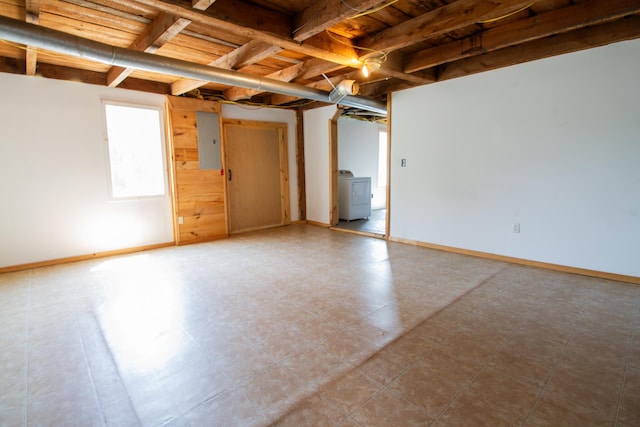 basement with electric panel and washer / dryer