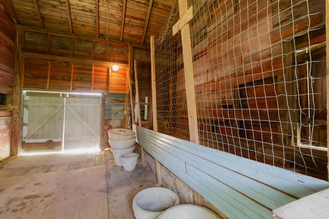 bathroom featuring wood ceiling, vaulted ceiling, and wood walls