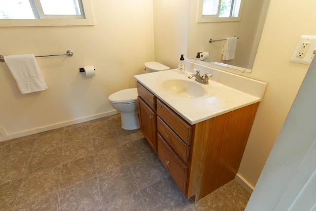 bathroom with toilet, a healthy amount of sunlight, and vanity