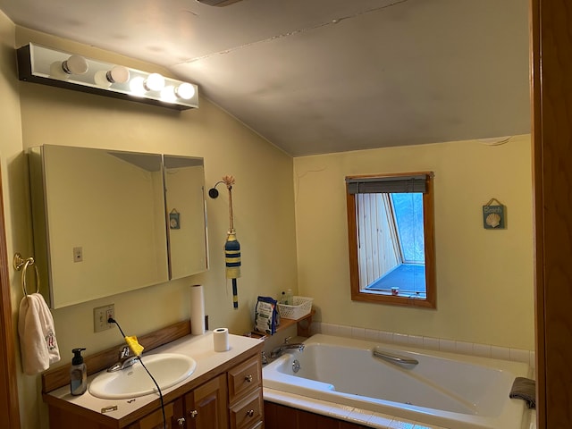 bathroom with lofted ceiling, vanity, and a relaxing tiled bath