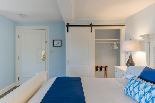 carpeted bedroom featuring a closet and a barn door