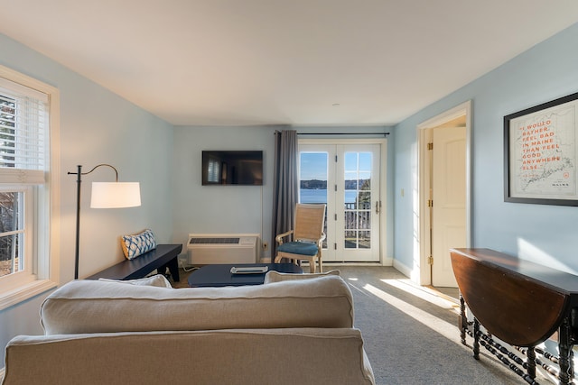 living room featuring light carpet, a water view, a wall mounted AC, and french doors