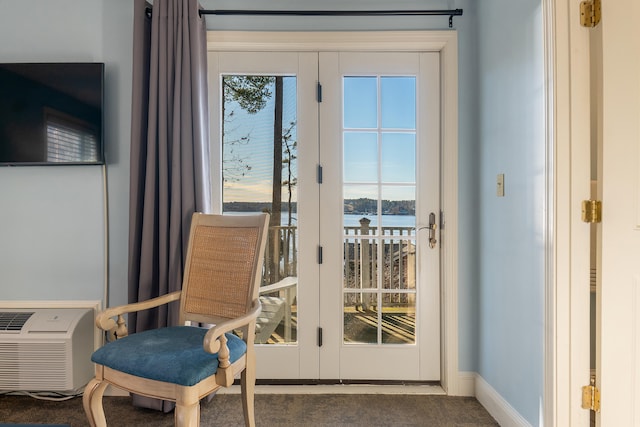 doorway to outside featuring a water view, dark colored carpet, french doors, and a wealth of natural light