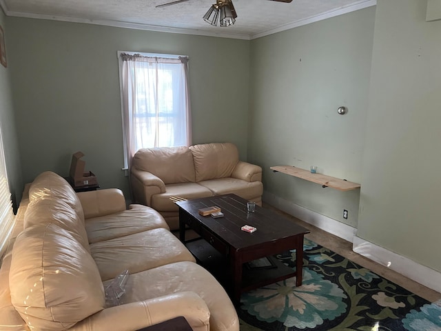 living room with ceiling fan, ornamental molding, and a textured ceiling