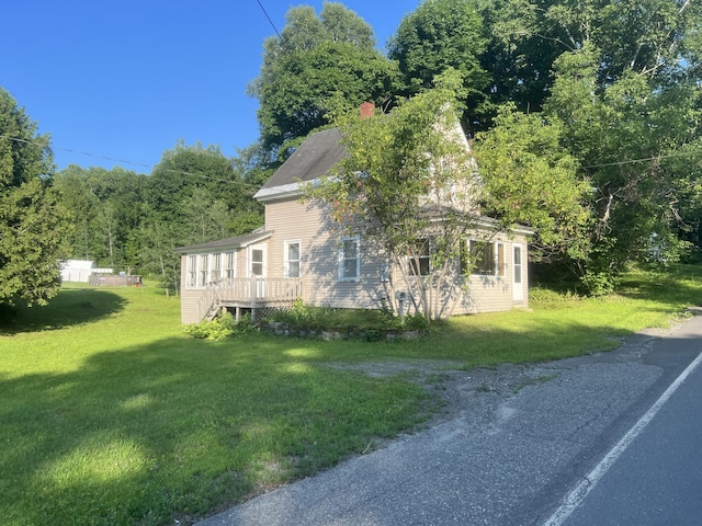 view of side of home featuring a lawn and a wooden deck