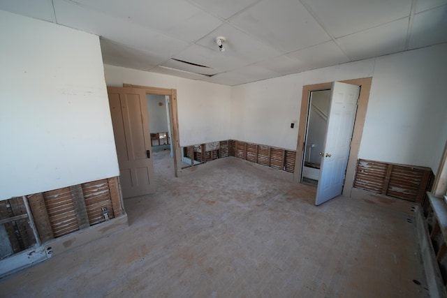 spare room featuring concrete floors and a paneled ceiling