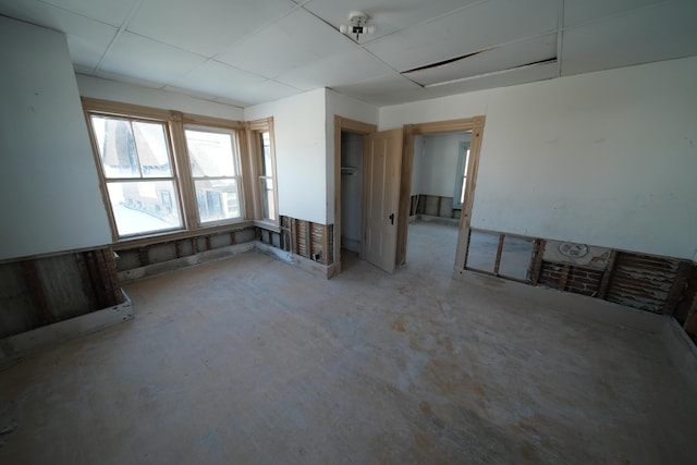 unfurnished room with a paneled ceiling and concrete floors