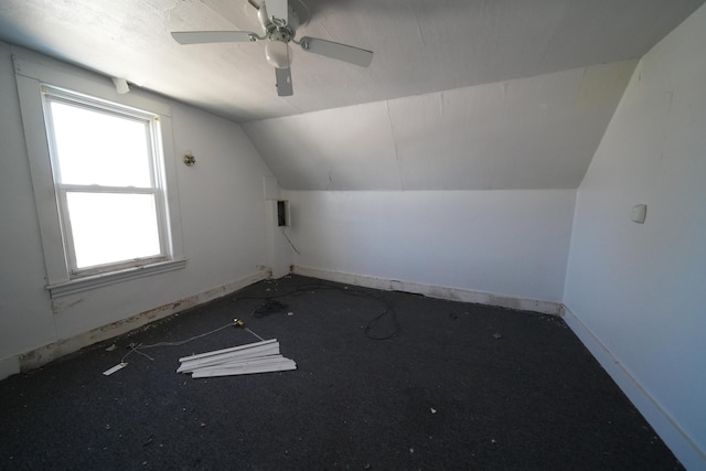 additional living space featuring a healthy amount of sunlight, lofted ceiling, and ceiling fan