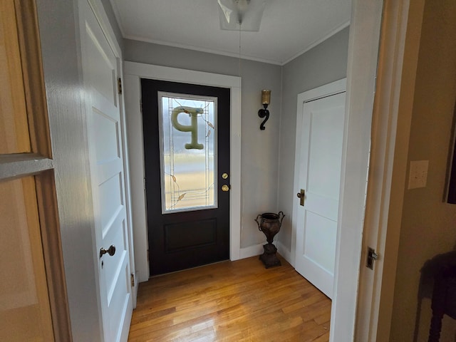 foyer entrance with light hardwood / wood-style flooring and ornamental molding