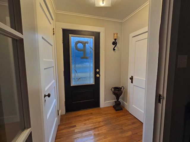 entryway featuring wood-type flooring and ornamental molding