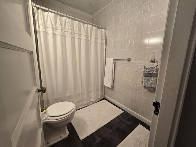 bathroom with ornamental molding, tile walls, toilet, and curtained shower