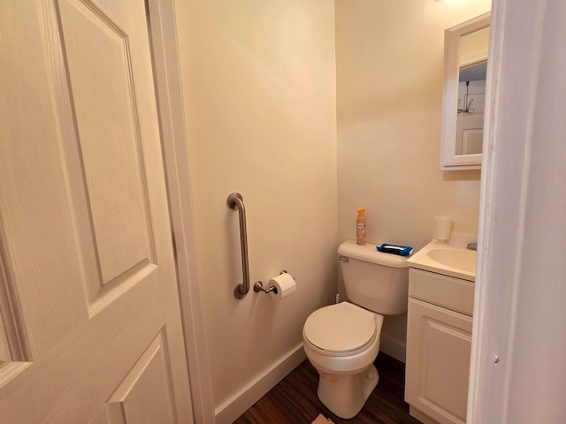 bathroom with wood-type flooring, vanity, and toilet