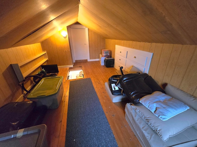 interior space with wooden walls, vaulted ceiling, and hardwood / wood-style floors