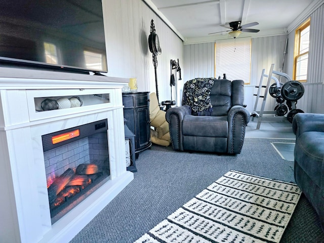 carpeted living room with crown molding, ceiling fan, and wood walls