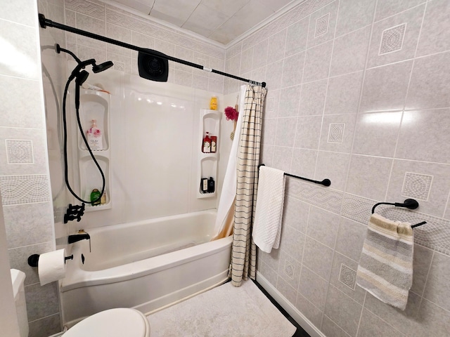 bathroom featuring tile walls, shower / tub combo, and toilet