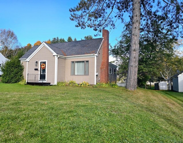 view of front of property featuring a front yard and a storage unit