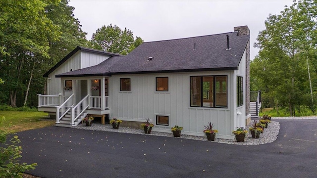 862 W Neck Rd, Nobleboro, ME 04555 - view of front facade with a shingled roof, a chimney, board and batten siding, and asphalt driveway