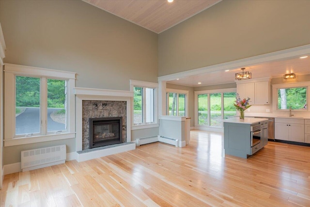 862 W Neck Rd, Nobleboro, ME 04555 - kitchen with radiator heating unit, light countertops, high vaulted ceiling, white cabinetry, and a baseboard radiator