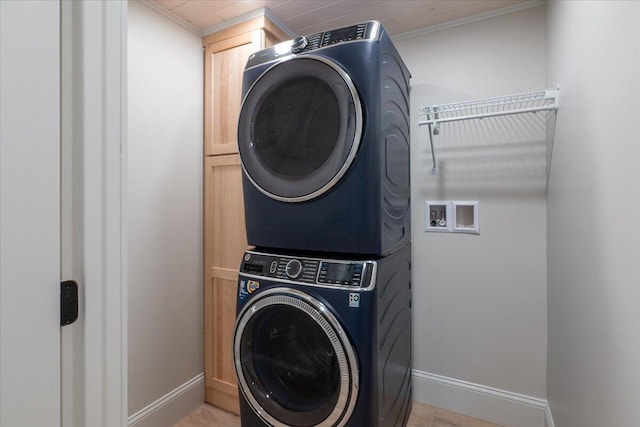862 W Neck Rd, Nobleboro, ME 04555 - washroom featuring stacked washer / drying machine, ornamental molding, cabinet space, and light wood-style flooring
