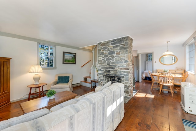 living room featuring dark hardwood / wood-style floors and a stone fireplace