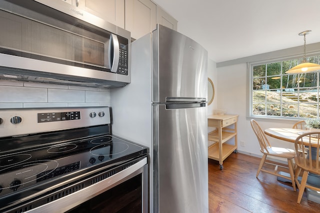 kitchen with dark hardwood / wood-style flooring, backsplash, pendant lighting, and stainless steel appliances