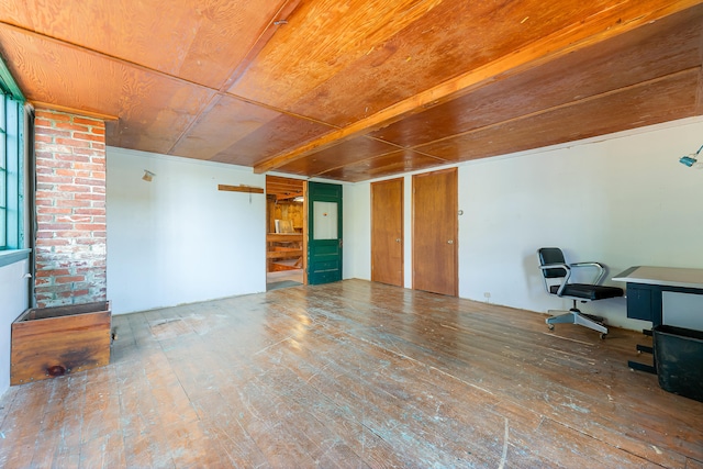 office with hardwood / wood-style floors and brick wall