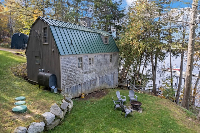 view of outdoor structure with a yard and an outdoor fire pit