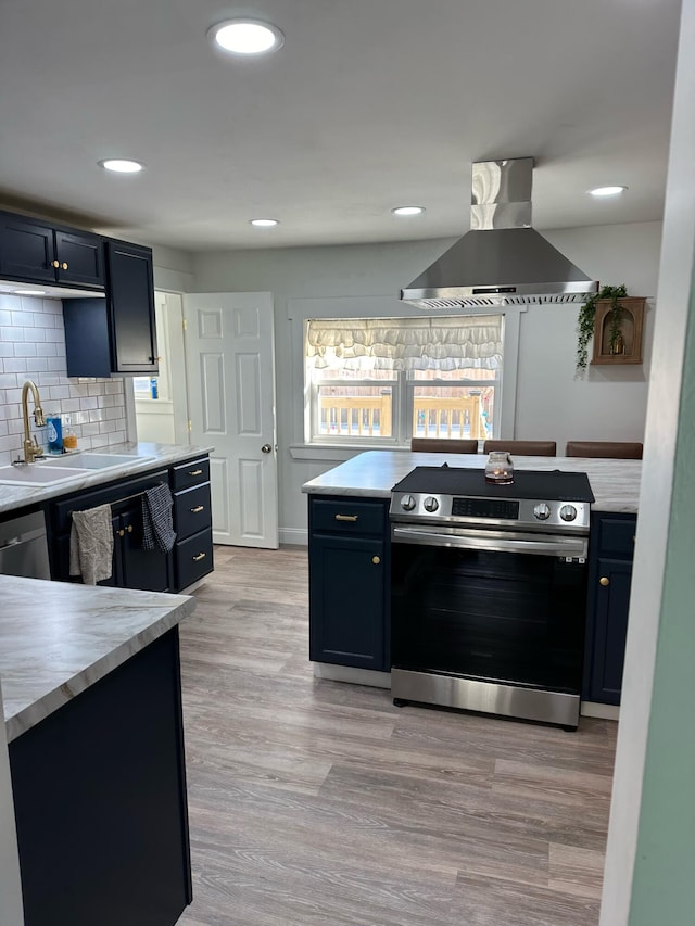 kitchen with backsplash, stainless steel appliances, island exhaust hood, and light hardwood / wood-style floors