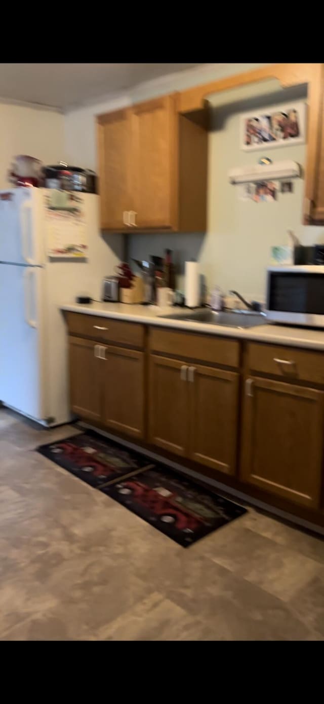 kitchen with dark tile floors, white appliances, and sink