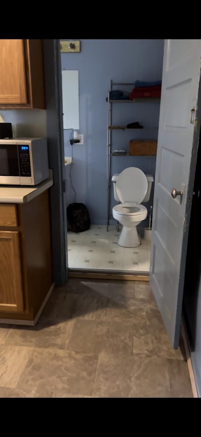 bathroom featuring toilet and tile floors