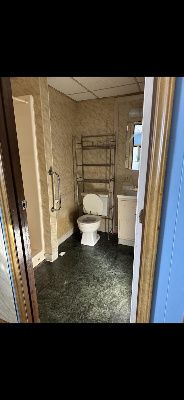 bathroom featuring vanity, walk in shower, tile floors, a paneled ceiling, and toilet