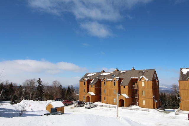 view of snow covered back of property