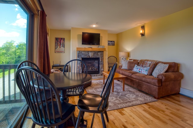 interior space featuring a fireplace, light wood-style flooring, and a healthy amount of sunlight