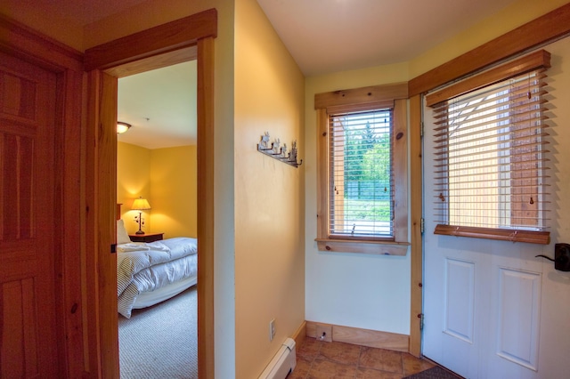 doorway featuring tile patterned floors, baseboards, and baseboard heating