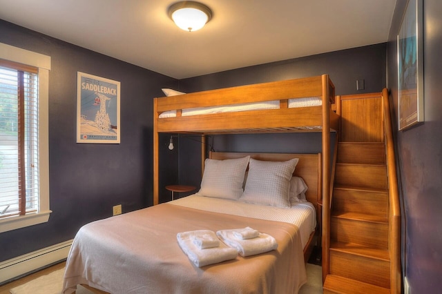 bedroom featuring baseboard heating and multiple windows