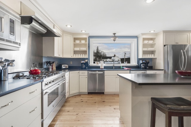 kitchen featuring light hardwood / wood-style floors, appliances with stainless steel finishes, sink, and a breakfast bar area