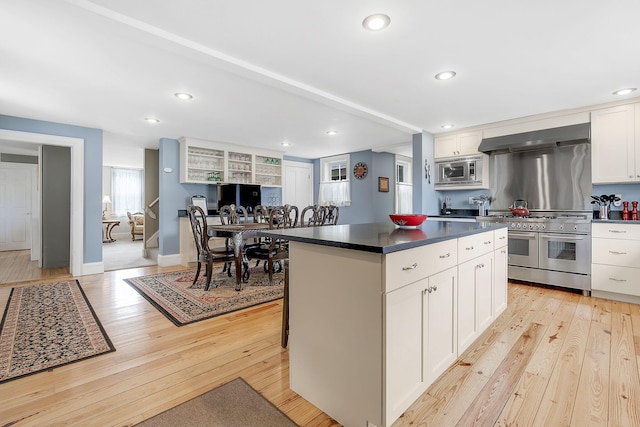 kitchen with a center island, light wood-type flooring, white cabinetry, and stainless steel appliances