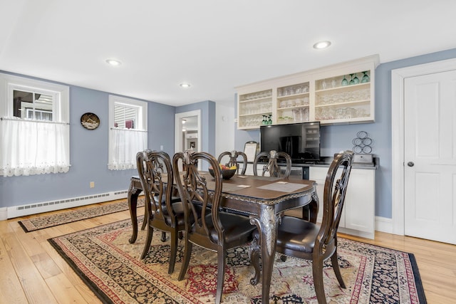 dining area with light hardwood / wood-style flooring and a baseboard radiator