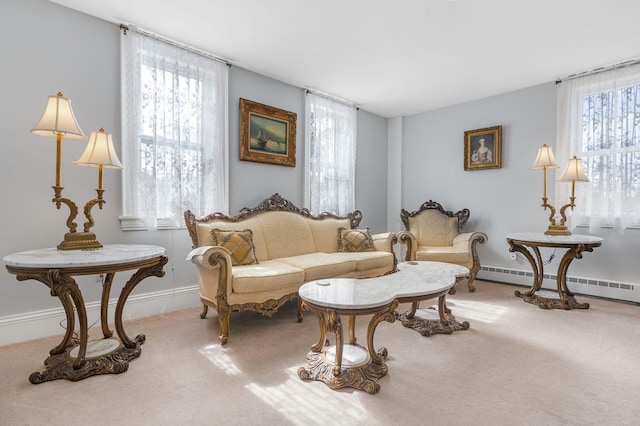 sitting room featuring a wealth of natural light, a baseboard heating unit, and carpet floors