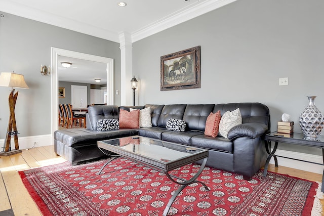 living room with hardwood / wood-style floors, ornate columns, and ornamental molding