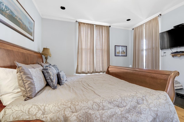 bedroom with light hardwood / wood-style flooring and ornamental molding