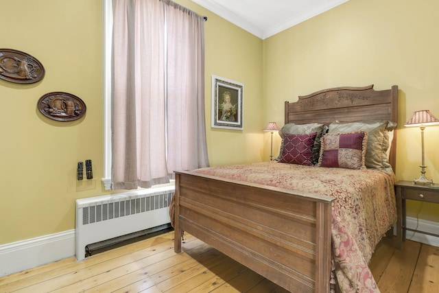 bedroom featuring light wood-type flooring, ornamental molding, and radiator heating unit