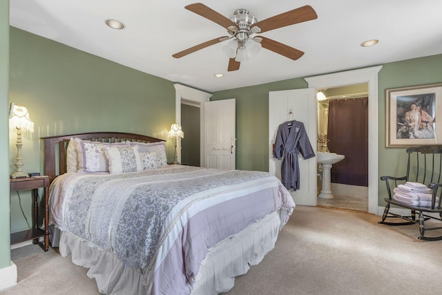 carpeted bedroom featuring ceiling fan and connected bathroom