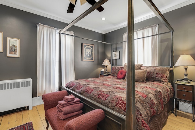 bedroom with radiator heating unit, light hardwood / wood-style floors, crown molding, and ceiling fan