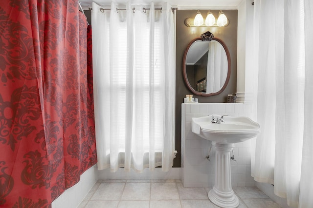 bathroom featuring tile walls, tile patterned flooring, and shower / bath combo with shower curtain