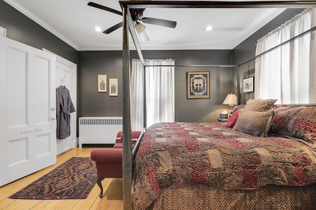 bedroom with ornamental molding, radiator, ceiling fan, and light hardwood / wood-style floors