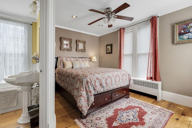 bedroom featuring radiator, ornamental molding, light hardwood / wood-style floors, and ceiling fan